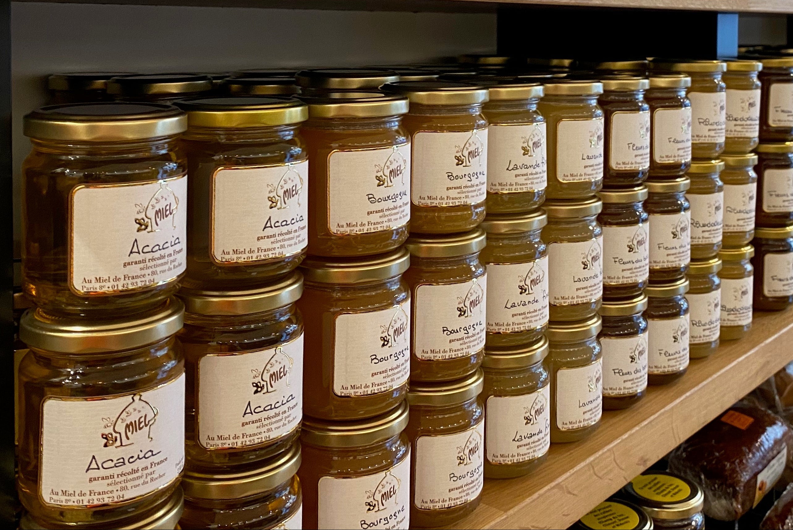 Sélection de miels artisanaux français présentés en boutique sur étagère à Paris